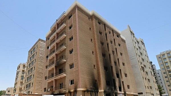 <div class="paragraphs"><p>Vehicles are parked next to a building damaged following a deadly fire, in Mangaf, southern Kuwait</p></div>