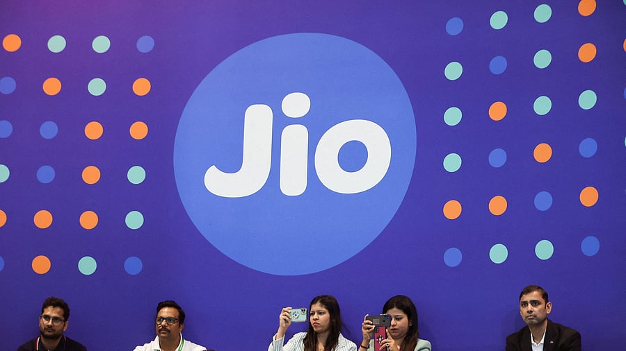 <div class="paragraphs"><p> People take pictures with their mobile phones in front of the logo of Jio.</p></div>