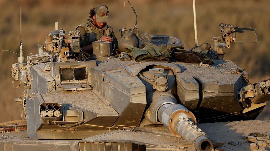 <div class="paragraphs"><p>An Israeli soldier on a tank holds position near the Israel-Gaza border</p></div>