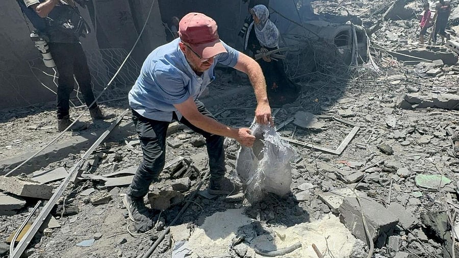 <div class="paragraphs"><p>A man holds a bag as Palestinians search for casualties at the site of Israeli strikes on houses in Gaza. </p></div>