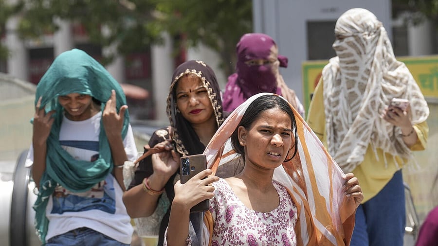 <div class="paragraphs"><p>Women cover their heads for protection from the scorching sun on a hot summer day, in New Delhi, Tuesday, June 18, 2024. The India Meteorological Department (IMD) has issued a 'red' alert because of prevailing heatwave conditions in the national capital. </p></div>