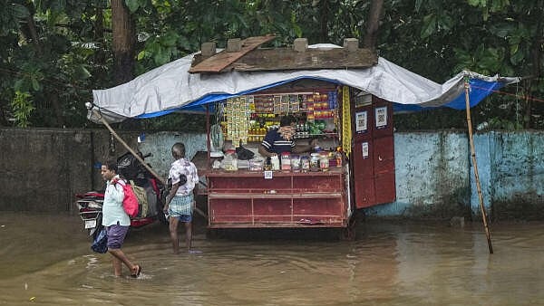 <div class="paragraphs"><p>A stall is covered with a sheet during rains, seen on a waterlogged street, in Mumbai</p></div>