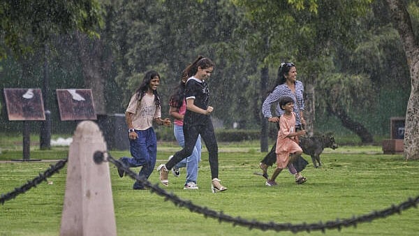 <div class="paragraphs"><p>People rush for cover during monsoon rain, at Kartavya Path, in New Delhi, Saturday, July 13, 2024.&nbsp;</p></div>