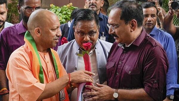 <div class="paragraphs"><p>Uttar Pradesh Chief Minister Yogi Adityanath being received by Delhi BJP President Virendra Sachdeva and others upon his arrival for a meeting at BJP headquarters, in New Delhi, Saturday. </p></div>