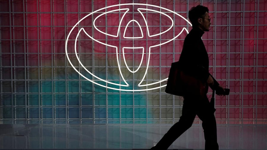 <div class="paragraphs"><p>A man walks past a Toyota logo at the Tokyo Motor Show.</p></div>
