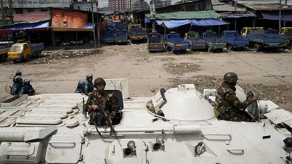 <div class="paragraphs"><p>Members of the Bangladesh Army are seen on an armoured vehicle during a curfew imposed in response to student-led protests against government job quotas, in Dhaka, Bangladesh. </p></div>