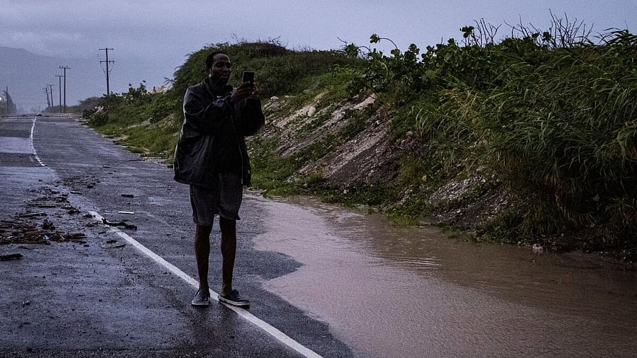 <div class="paragraphs"><p>A man uses his phone to record a flooded road as Hurricane Beryl hits the southern coast of the island, in Kingston, Jamaica.</p></div>