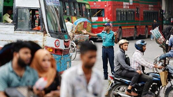 <div class="paragraphs"><p>A policeman gestures to vehicles at Shahbagh intersection to control traffic as Bangladeshi police return on duty, following the resignation of former Prime Minister Sheikh Hasina, in Dhaka, Bangladesh, August 12, 2024.</p></div>