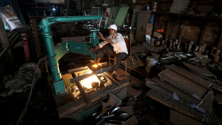<div class="paragraphs"><p> A worker operates a machine inside a small scale manufacturing unit in Mumbai, India, February 1, 2023.</p></div>