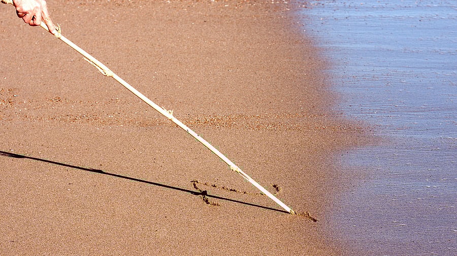 <div class="paragraphs"><p>Image of a man writing on wet soil with a stick (for representative purposes).</p></div>