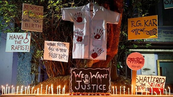 <div class="paragraphs"><p>Candles burn, as posters hang on a tree in protest against alleged rape and murder of a trainee doctor, inside the premises of Dr. R. Ahmed Dental College and Hospital in Kolkata. </p></div>
