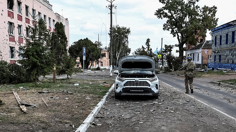 <div class="paragraphs"><p>A Ukrainian serviceman patrols a street next to buildings, damaged during recent fighting between Ukrainian and Russian forces in controlled by Ukrainian army the town of Sudzha, Kursk region.</p></div>