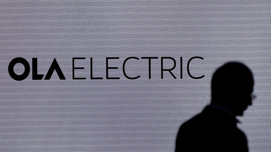 <div class="paragraphs"><p>A man walks past the logo of Ola Electric during a press conference ahead of it's IPO launch in Mumbai.</p></div>