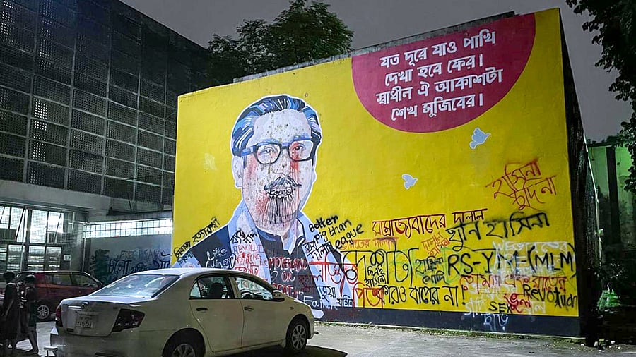 <div class="paragraphs"><p>Dhaka: A mural depicting first president of Bangladesh Sheikh Mujibur Rahman, defaced with graffiti scrawled on a wall in the campus of the Dhaka University, Friday, Aug. 23, 2024.</p></div>