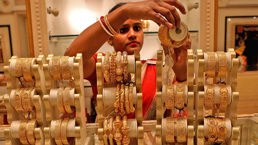 <div class="paragraphs"><p>A saleswoman shows gold bangles to a customer at a jewellery showroom on the occasion of Akshaya Tritiya, a major gold buying festival. </p></div>