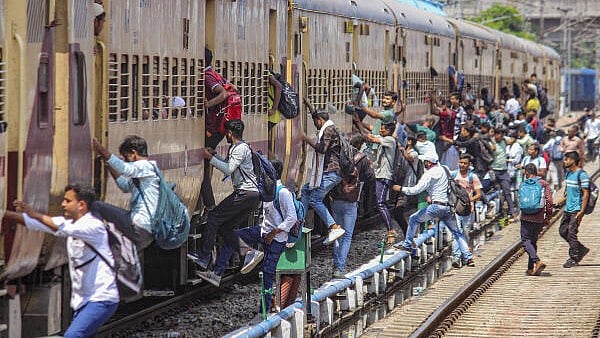 <div class="paragraphs"><p>Candidates rush to board a train at the railway station after the UP police recruitment exam, in Meerut. </p></div>