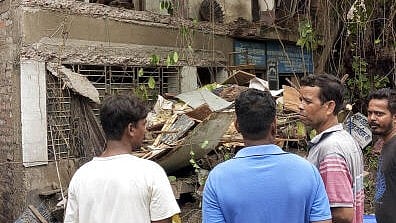 <div class="paragraphs"><p>People gather near the site of a building due that partially collapsed due to rain, at Baguihati area, in Kolkata, Friday. </p></div>