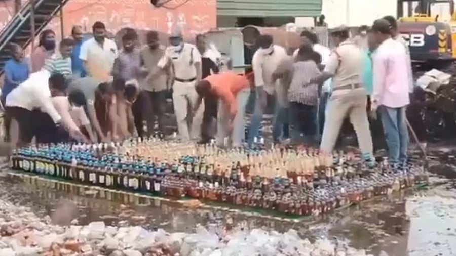 <div class="paragraphs"><p>Screengrab from a video of the incident, which shows the mob grabbing illicit liquor bottles confiscated the police for disposal, in Guntur, Andhra Pradesh.</p></div>