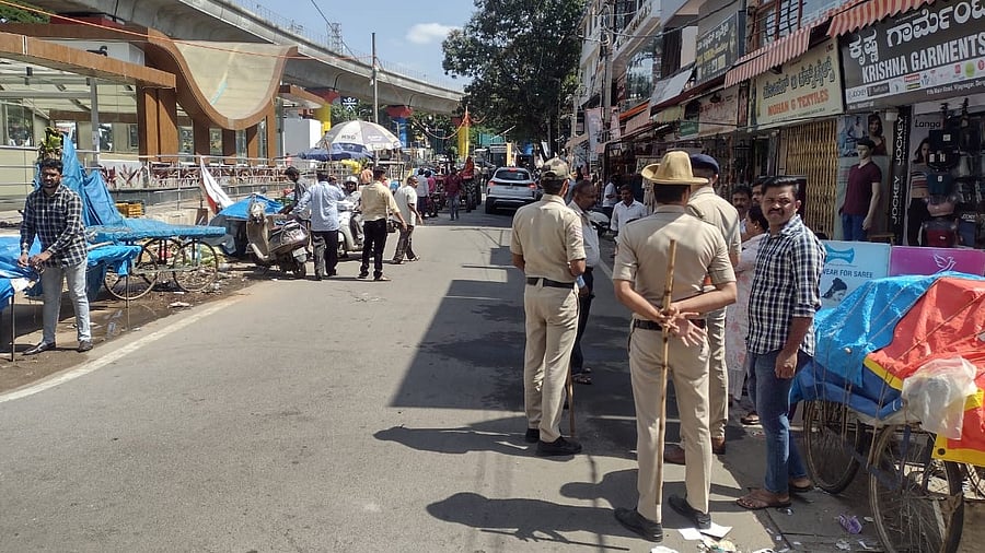 Police stand guard as the structures are bring removed on the service road in Vijayanagar. SPECIAL ARRANGEMENT