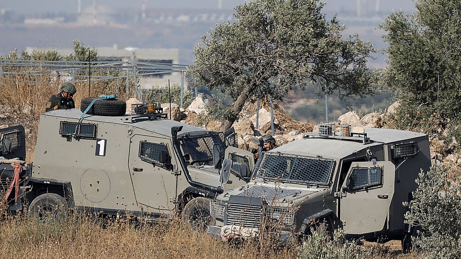 <div class="paragraphs"><p>Israeli forces take positions behind vehicles, during a military operation, in the Israeli-occupied West Bank.</p></div>