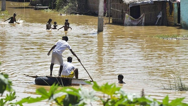 <div class="paragraphs"><p>People use a makeshift boat to reach a safer place at a flood-affected area, in Bind Tola of Patna, Saturday, September 21, 2024.</p></div>