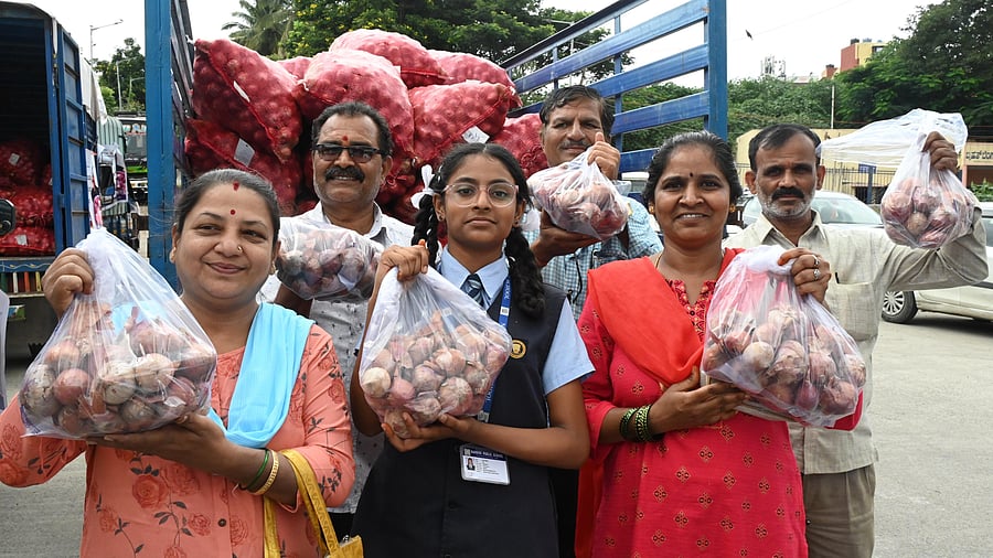 <div class="paragraphs"><p>People show pack of onion after buying it at the Rs 35 from a mobile van at Nandini layout in Bengaluru on Monday.</p></div>