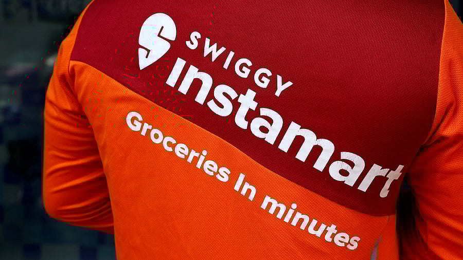 <div class="paragraphs"><p>A gig worker waits to pick an order outside a Swiggy's grocery warehouse.</p></div>