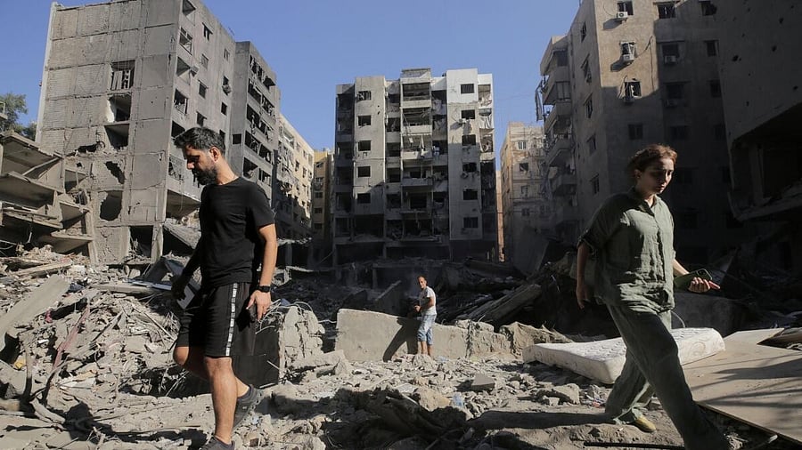 <div class="paragraphs"><p>People walk on the rubble at the site of the Israeli airstrike that killed Lebanon's Hezbollah leader Sayyed Hassan Nasrallah on Friday, in Beirut's southern suburbs.</p></div>