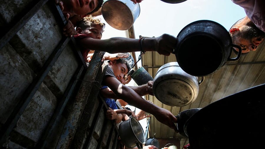 <div class="paragraphs"><p>Palestinians gather to receive food cooked by a charity kitchen, amid the Israel-Hamas conflict, in Khan Younis, southern Gaza Strip. </p></div>