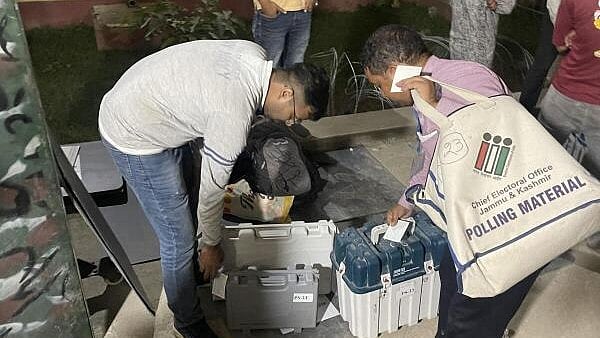 <div class="paragraphs"><p> Polling officials with EVMs and other polling materials return to a strong room after the conclusion of the third and final phase of J&K Assembly elections, in Kathua district, J&K.</p></div>