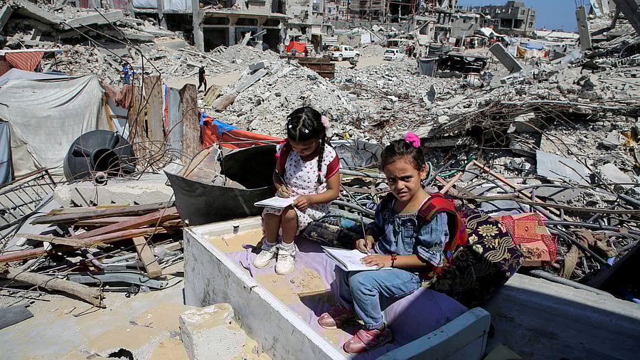 FILE PHOTO: Palestinian students sit on the rubble after attending a class in a tent set up on the ruins of the house of teacher Israa Abu Mustafa, as war disrupts a new school year, amid the Israel-Hamas conflict, in Khan Younis, in the southern Gaza Strip, September 4, 2024. REUTERS/Hatem Khaled/File Photo/File Photo