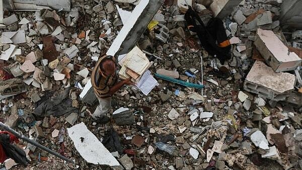 <div class="paragraphs"><p>A Palestinian collects copies of the Koran at the site of an Israeli strike on a mosque sheltering displaced people, amid Israel-Hamas conflict, in Deir Al-Balah, in the central Gaza Strip. </p></div>