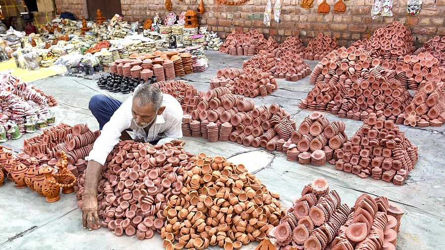 <div class="paragraphs"><p>A vendor arranges earthen lamps (Diya) for sale, in Bikaner.</p></div>