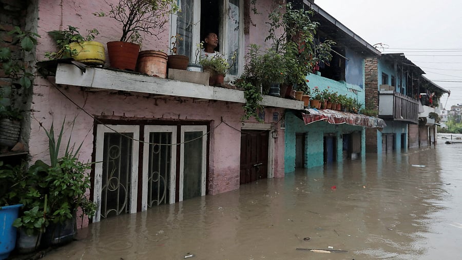 <div class="paragraphs"><p>A man looks out from the window of his house in an area flooded by the overflowing Bagmati river following heavy rains, in Kathmandu, Nepal August 8, 2023.</p></div>