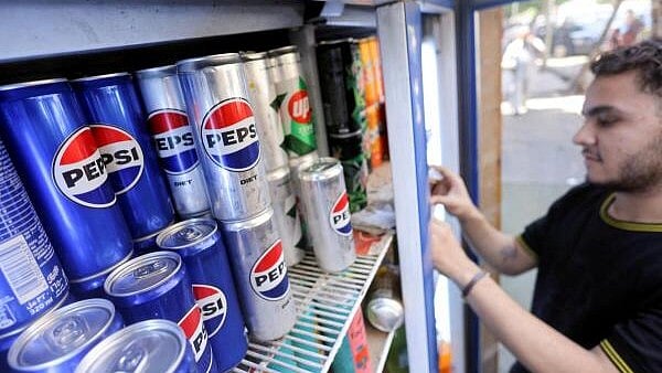 <div class="paragraphs"><p>An Egyptian supermarket owner arranges cans of soft drinks by PepsiCo on a shelf in Cairo, Egypt. </p></div>