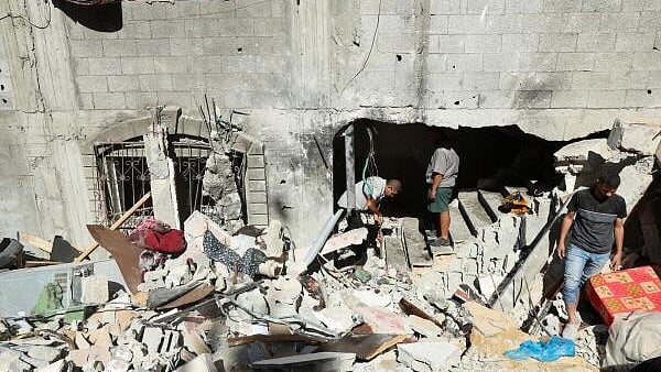 <div class="paragraphs"><p>Palestinians inspect the site of an Israeli strike on a house, amid the ongoing Israel-Hamas conflict, in Al Maghazi refugee camp in the central Gaza Strip. </p></div>