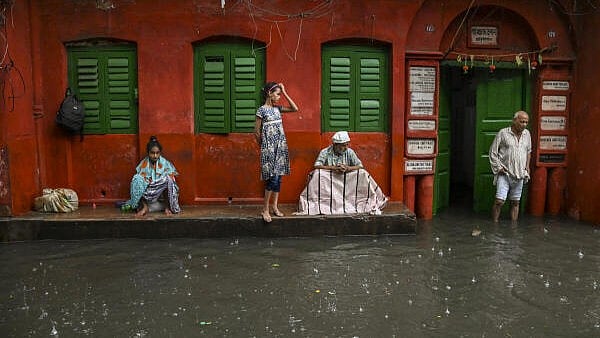<div class="paragraphs"><p>People take shelter during rain in the aftermath of cyclone 'Dana', in Kolkata, Friday. </p></div>