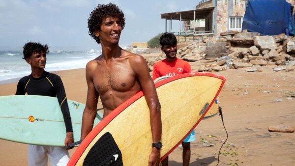 <div class="paragraphs"><p>Attiq Ur Rehman, 21, walks with his teammates along the beach as they prepare to surf at Turtle Beach in Karachi, Pakistan. </p></div>