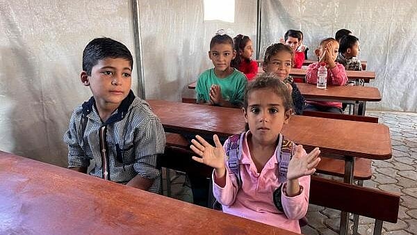 <div class="paragraphs"><p>Palestinian children attend a class in a makeshift school in Khan Younis in the southern Gaza Strip.</p></div>