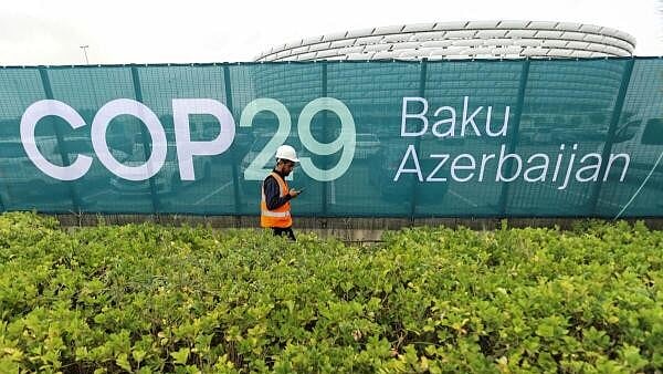 <div class="paragraphs"><p>A worker walks along a fence near the Baku Olympic Stadium, the venue of the COP29 United Nations Climate Change Conference, in Baku, Azerbaijan.</p></div>