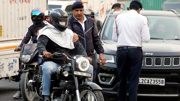 <div class="paragraphs"><p>A traffic police personnel stops a motorcyclist to check the Pollution Under Control (PUC) certificate of his bike, in New Delhi, Wednesday. </p></div>