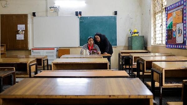 <div class="paragraphs"><p>School teachers conduct online classes using a mobile phone in an empty classroom after schools were ordered shut by the Delhi government as Delhi's air quality worsened due to air pollution, on a smoggy morning in New Delhi. </p></div>