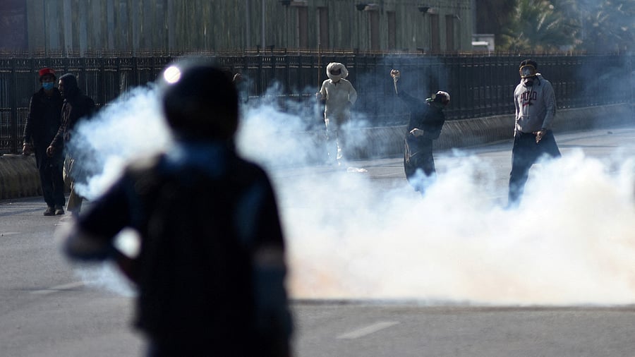 <div class="paragraphs"><p>A supporter of the jailed former Pakistani PM Imran Khan's party Pakistan Tehreek-e-Insaf (PTI) throws an object towards security force personnel.&nbsp;</p></div>