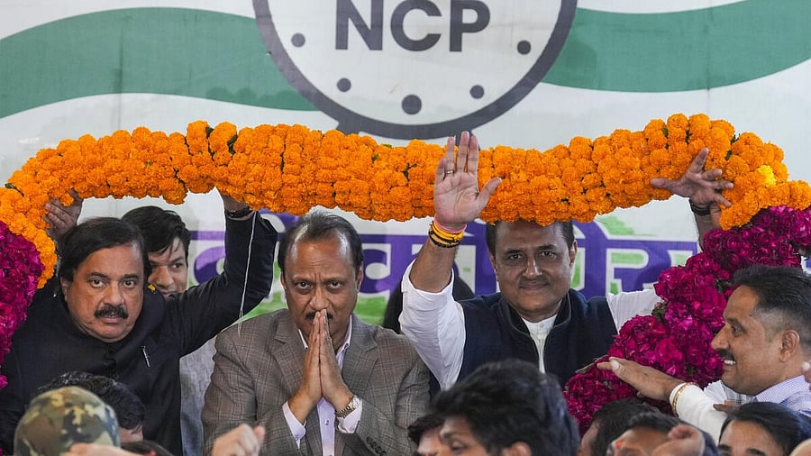 <div class="paragraphs"><p>NCP chief Ajit Pawar with party leader Praful Patel being garlanded by supporters during his visit to the party office, in New Delhi</p></div>
