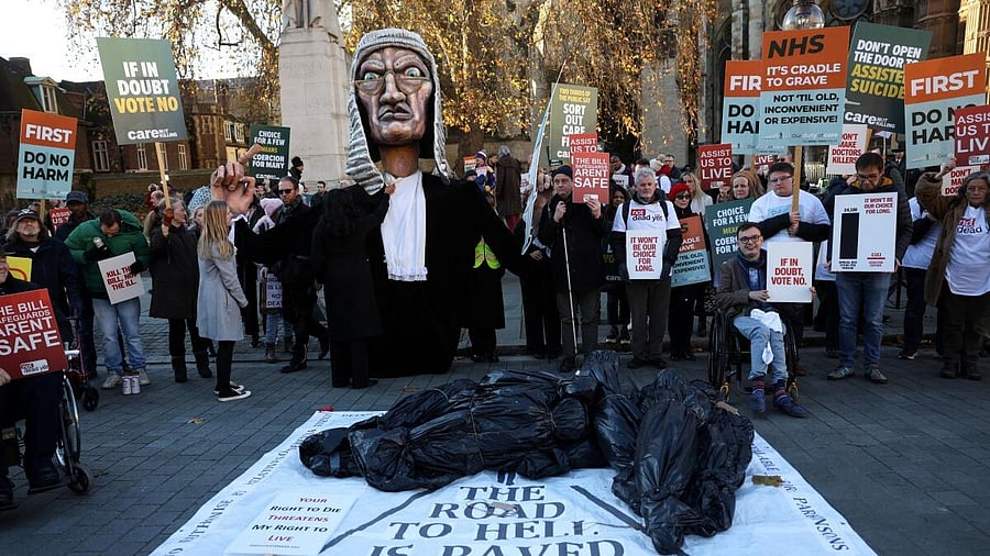 <div class="paragraphs"><p>Protestors hold placards as they gather outside the Parliament with British lawmakers debating the assisted dying law in London.</p></div>
