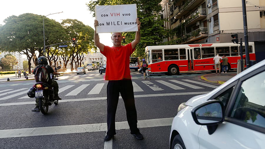 <div class="paragraphs"><p>Claudio Mariani, 59, who  was diagnosed as HIV positive in 1993, holds a placard that reads "with HIV I live, with Milei I die", in Buenos Aires, Argentina, November 29, 2024. </p></div>