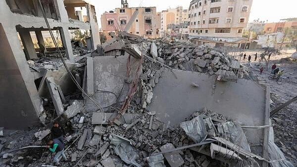 <div class="paragraphs"><p>Palestinians gather at the site of an Israeli strike on a house, amid the Israel-Hamas conflict, in Nuseirat in the central Gaza Strip.&nbsp;</p></div>