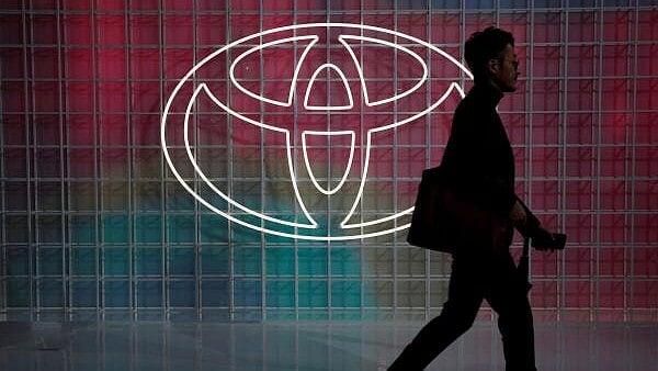 <div class="paragraphs"><p>A man walks past a Toyota logo.</p></div>