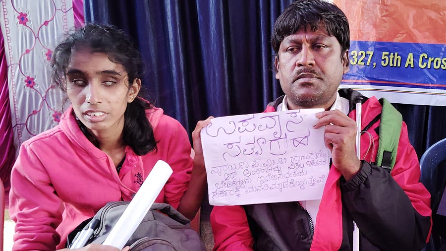 <div class="paragraphs"><p>Caption: Rani T R sits with Narayanaswamy protests against the delay by the government to appoint her as teacher despite obtaining an order from the high court.</p></div>