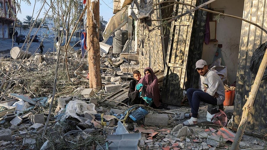 <div class="paragraphs"><p>Palestinians sit amid rubble at the site of an Israeli strike on a house in central Gaza.</p></div>